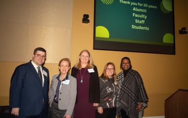 photo of faculty and staff in front of a yellow wall