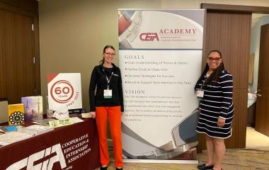 andrea and iteeah pose in front of a conference poster