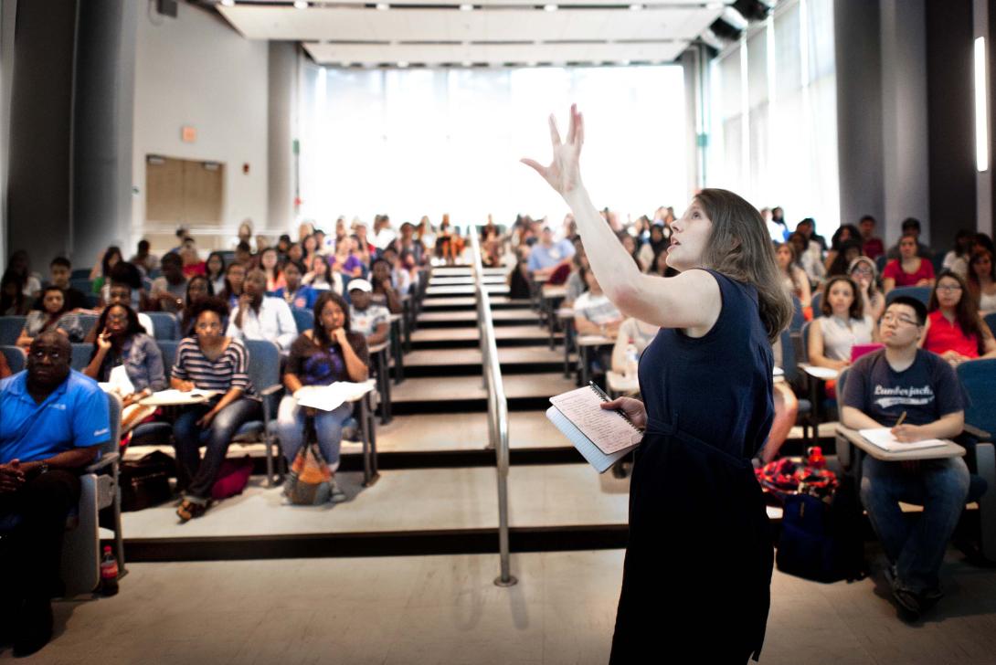 teacher standing in front of class in auditorium