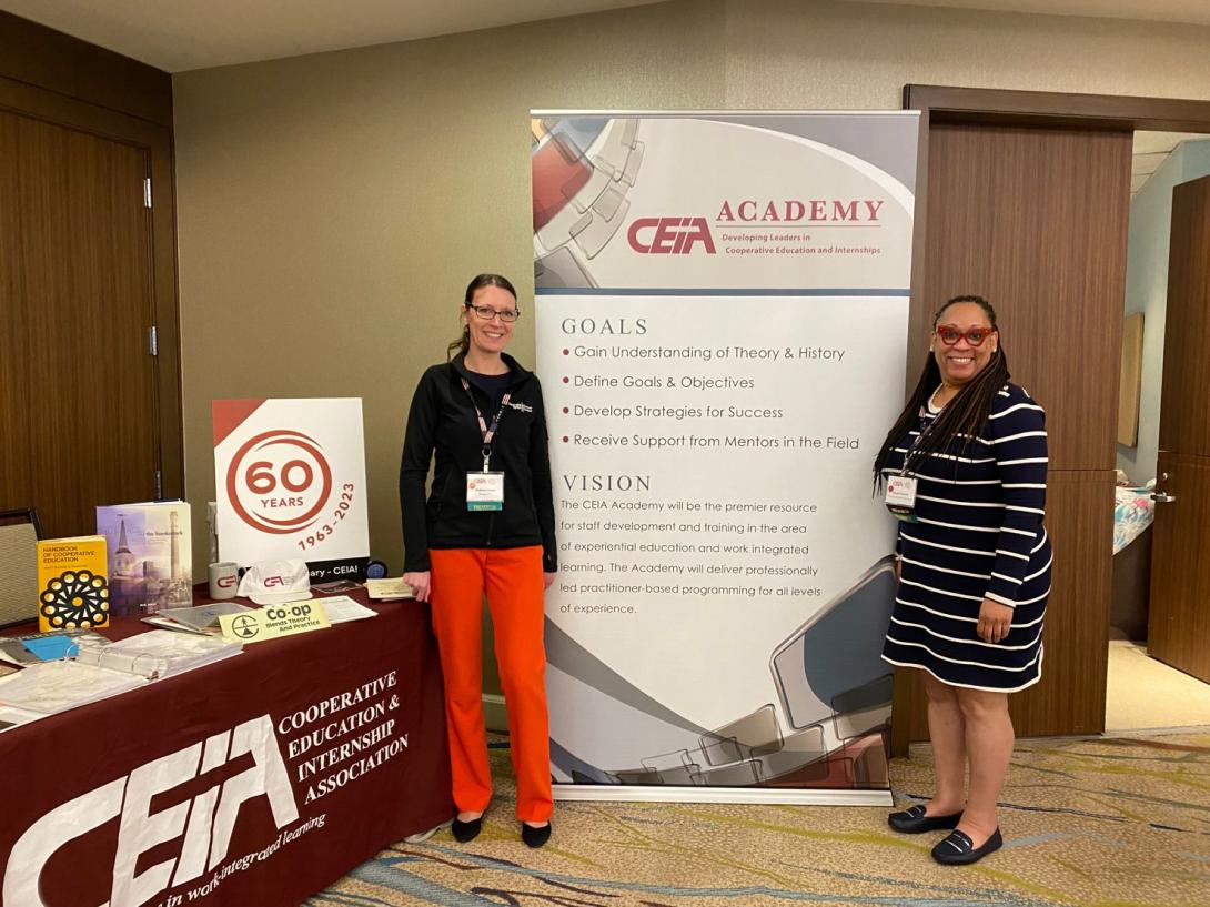 andrea and iteeah pose in front of a conference poster